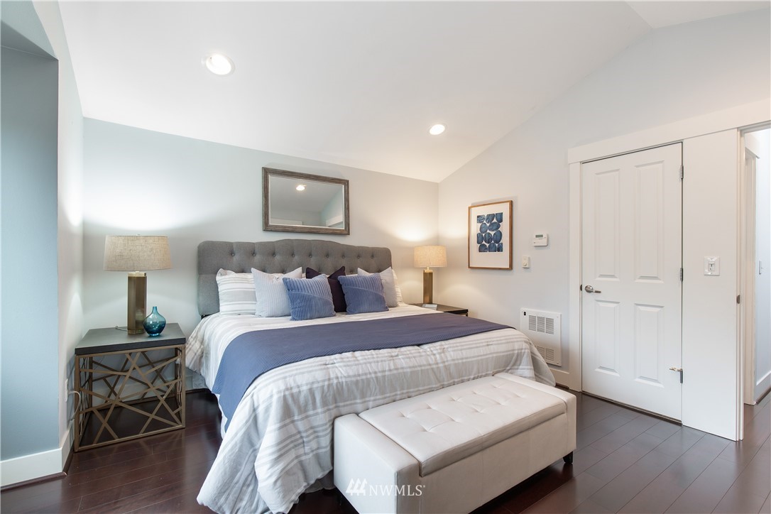 10303 Holman Road North, Unit A Seattle, WA 98177 - Photo 26 of 40 a bedroom with a bed and wooden floor