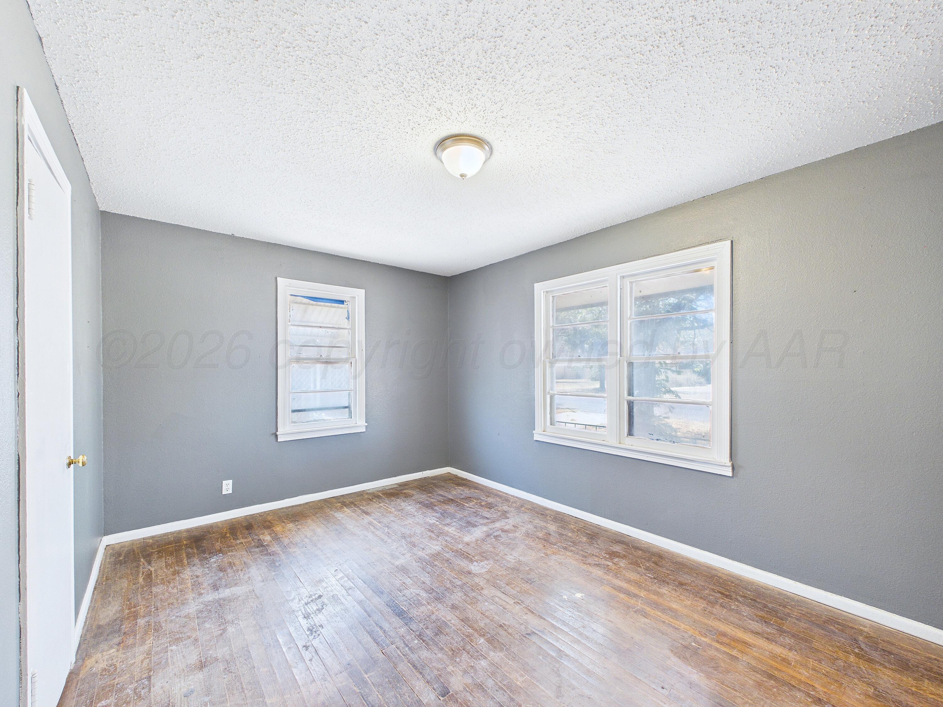 4311 Bowie Street Amarillo, TX 79110 - Photo 15 of 36 a view of an empty room with wooden floor and a window