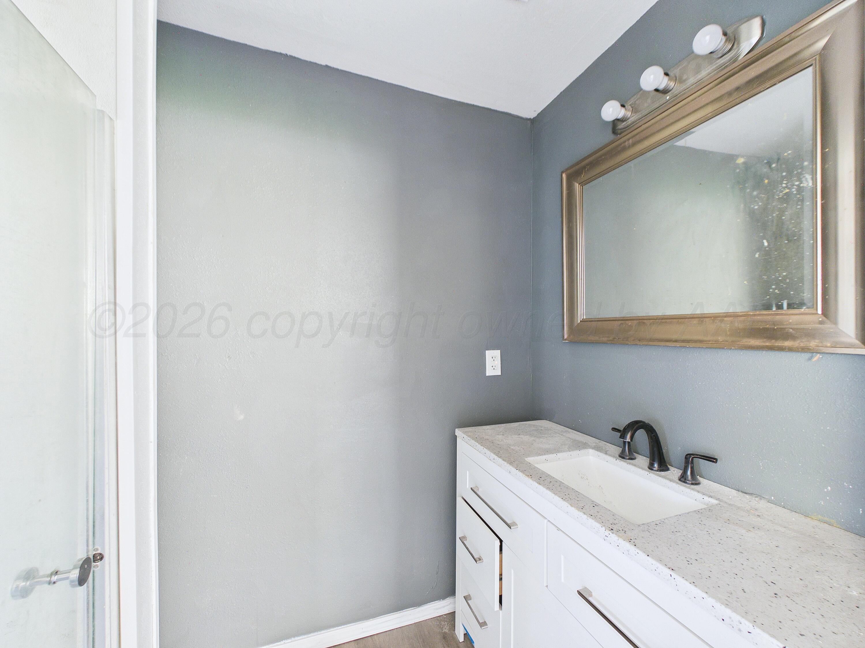 4311 Bowie Street Amarillo, TX 79110 - Photo 19 of 36 a bathroom with a sink vanity and a mirror