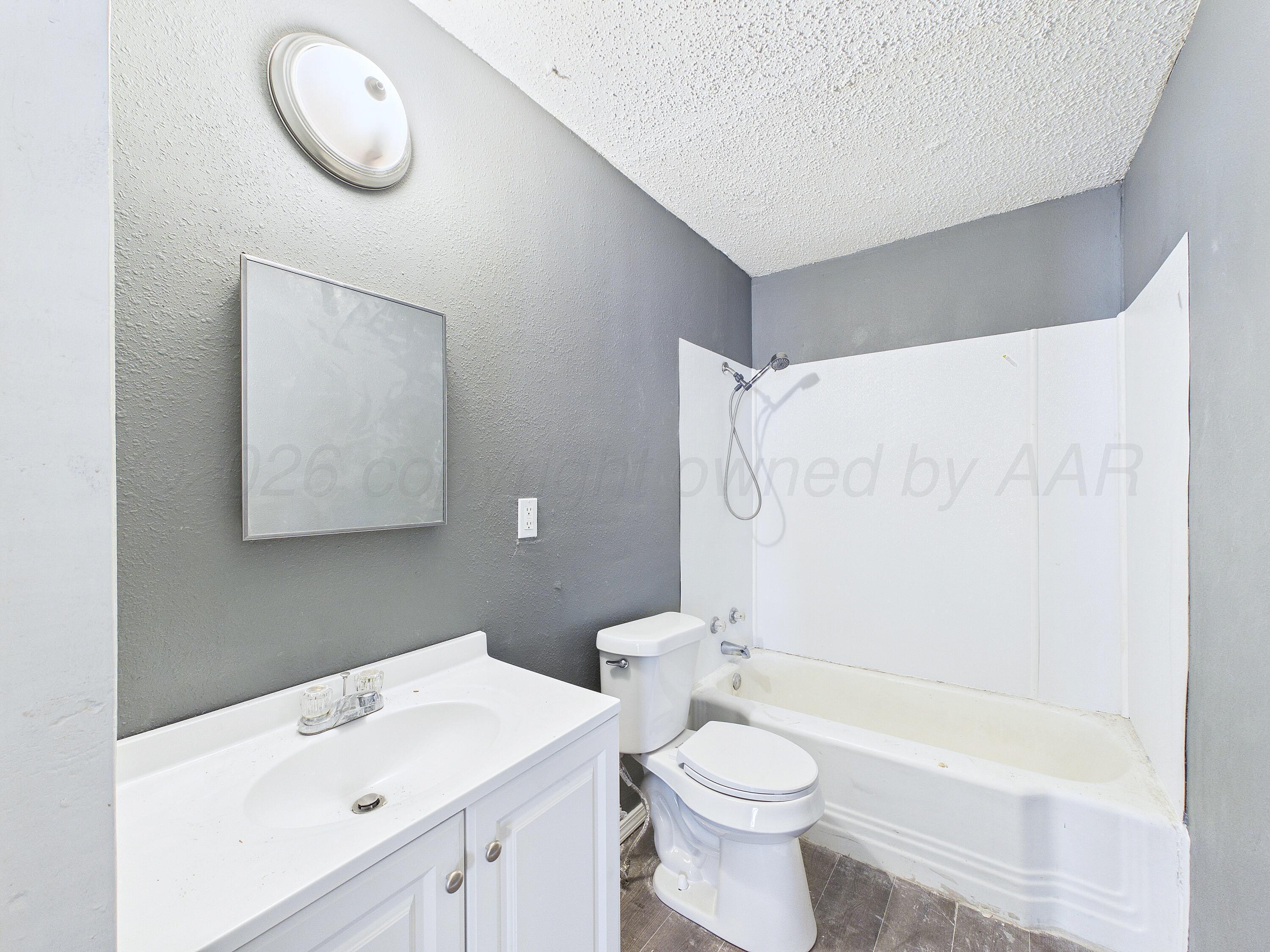 4311 Bowie Street Amarillo, TX 79110 - Photo 33 of 36 a bathroom with a sink a toilet and a bathtub