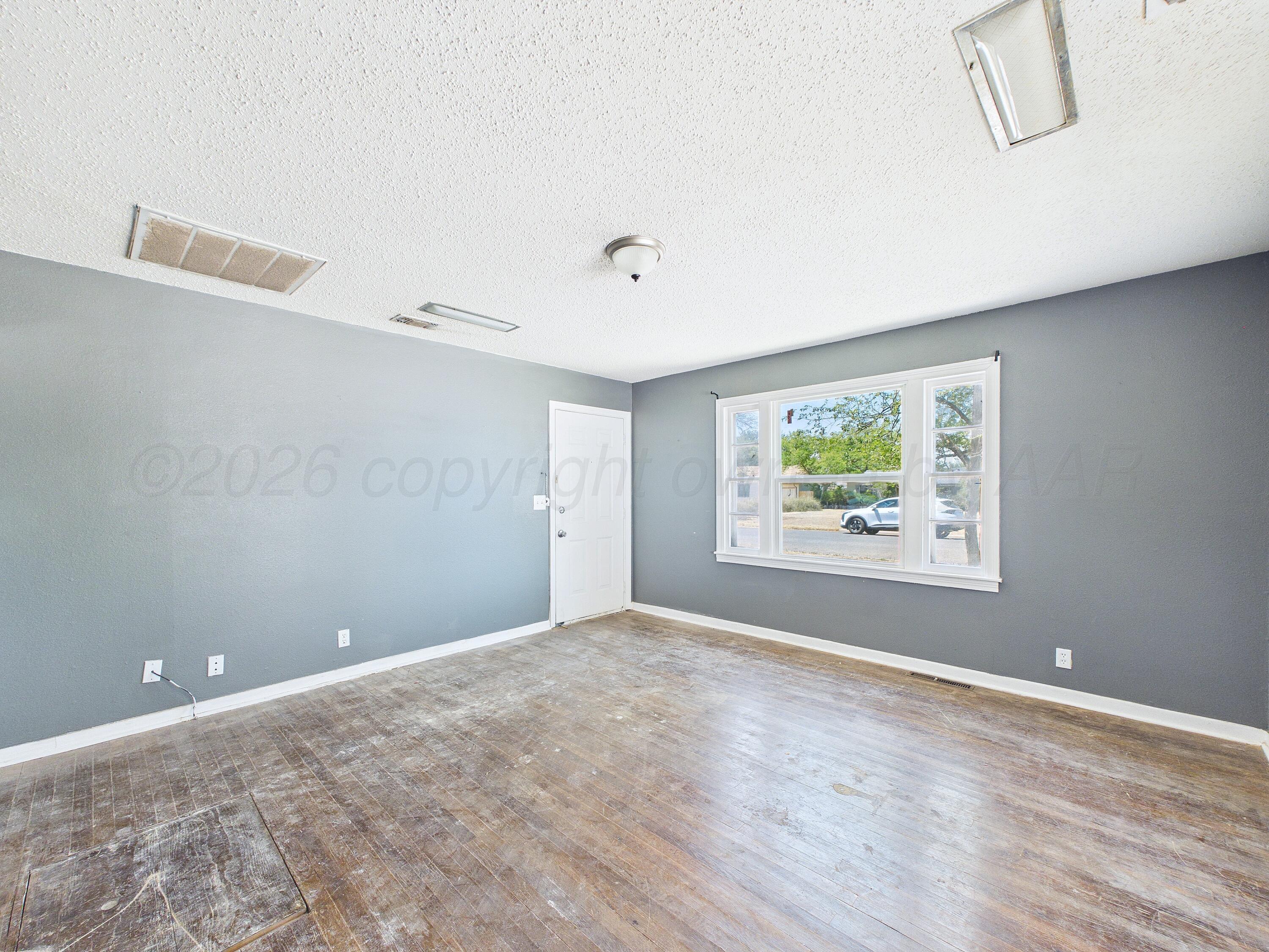 4311 Bowie Street Amarillo, TX 79110 - Photo 36 of 36 a view of an empty room with wooden floor and a window