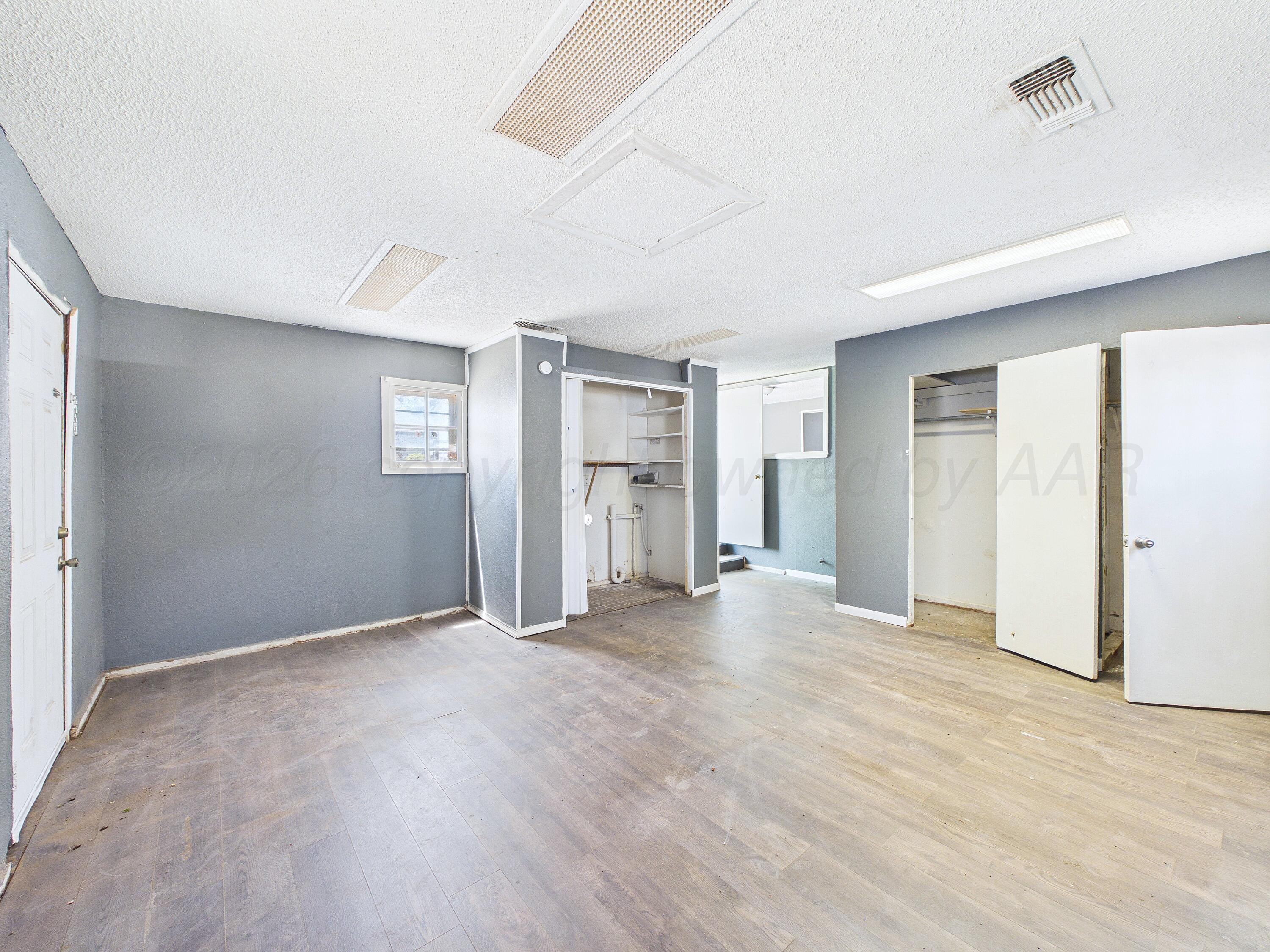 4311 Bowie Street Amarillo, TX 79110 - Photo 5 of 36 a view of an empty room with window and wooden floor