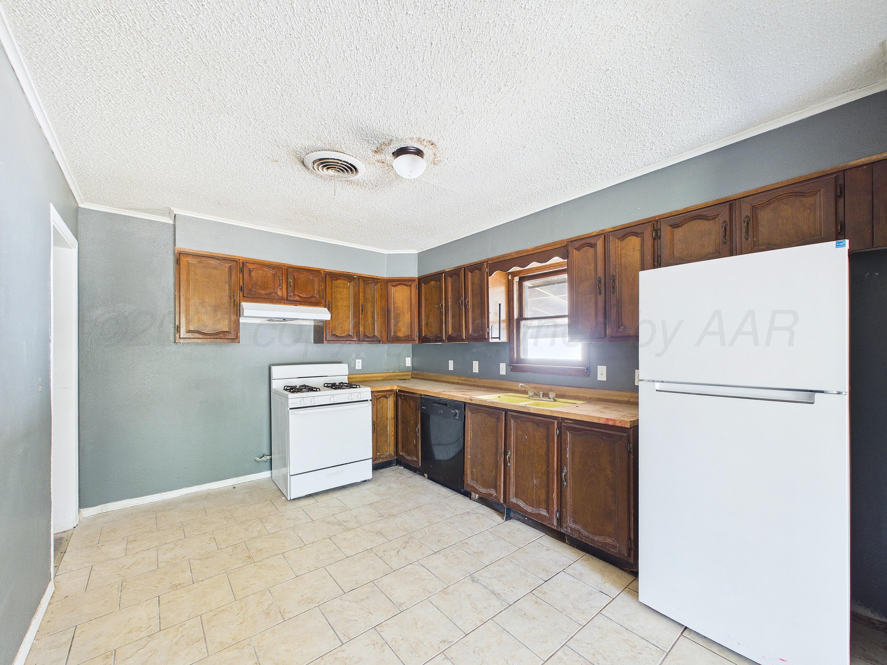 4311 Bowie Street Amarillo, TX 79110 - Photo 9 of 36 a kitchen with a refrigerator and a sink