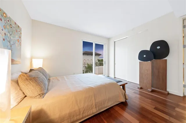 a bedroom with a large bed and a lamp next to a window