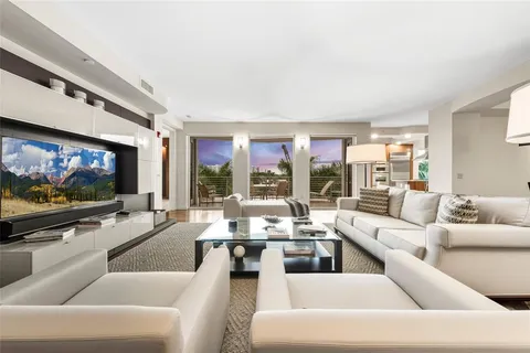 a living room with furniture flat screen tv and a large window