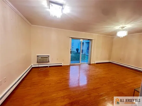 a view of an empty room with window and wooden floor