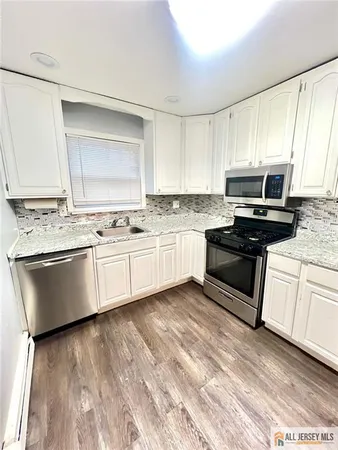 a kitchen with granite countertop white cabinets and white appliances