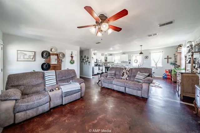 a living room with furniture kitchen view and a chandelier