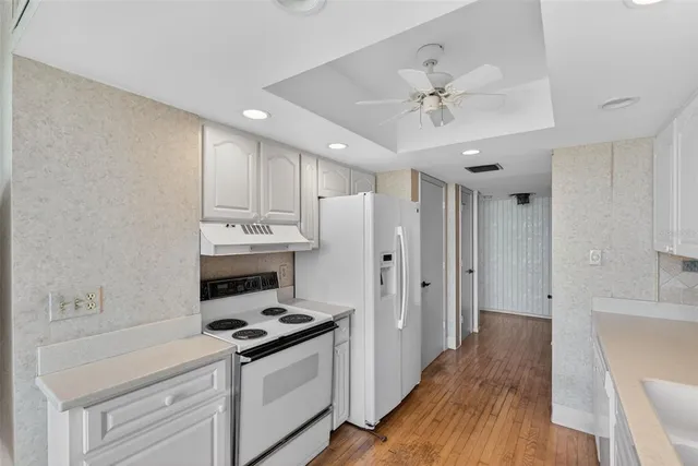 a kitchen with stainless steel appliances a stove a refrigerator and white cabinets