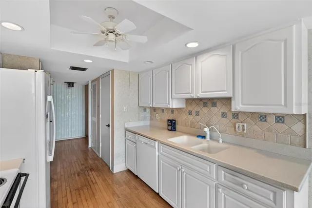 a kitchen with a sink a refrigerator and cabinets