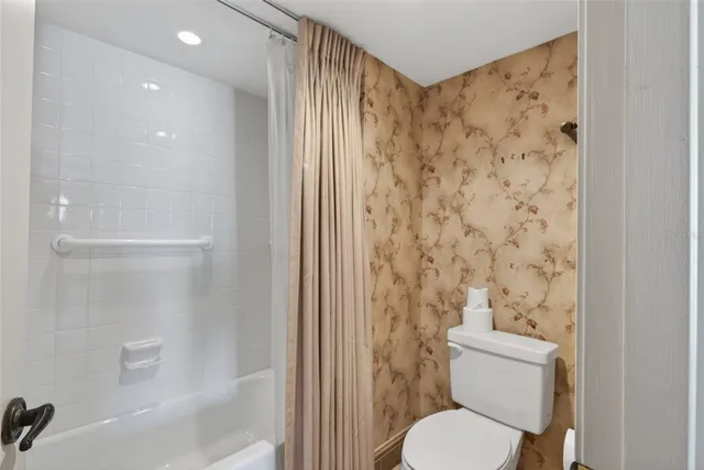 a bathroom with a toilet and a shower
