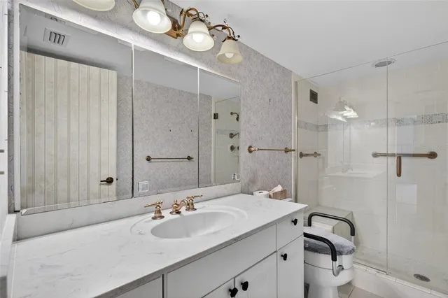 a bathroom with a sink a toilet and shower