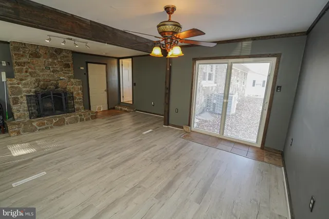 a view of an empty room with glass door and a window