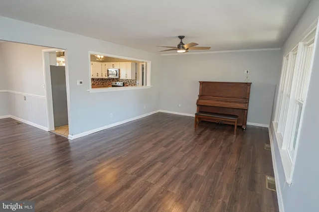 a view of a livingroom with wooden floor and a ceiling fan
