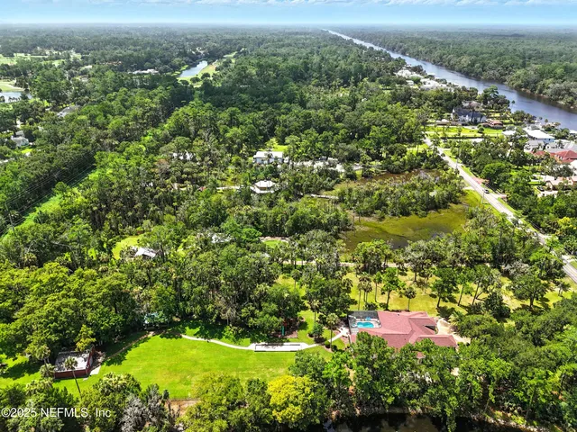 an aerial view of residential houses with outdoor space and trees