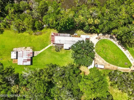 an aerial view of a house with a yard swimming pool outdoor seating and yard