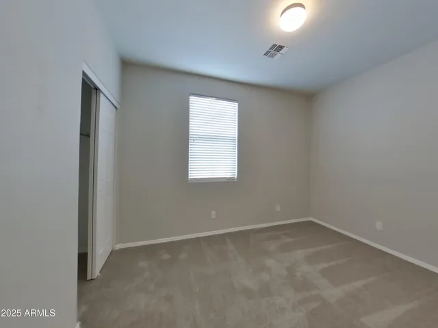 an empty room with fan and windows