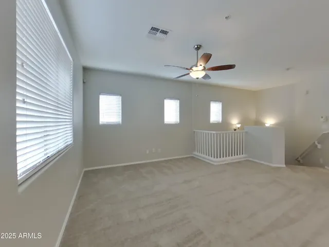 an empty room with windows and fan