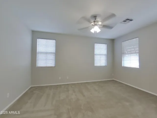 a view of an empty room with a ceiling fan