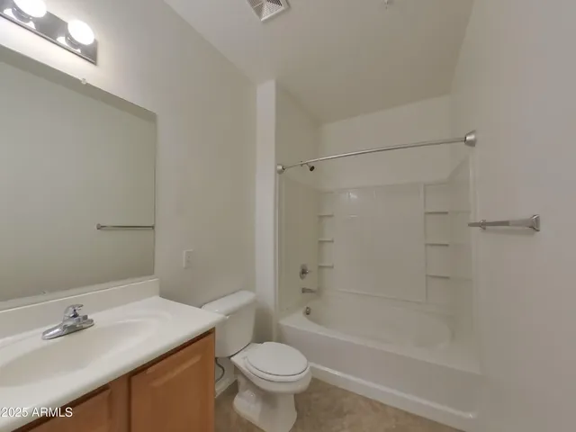 an empty room with closet and a ceiling fan