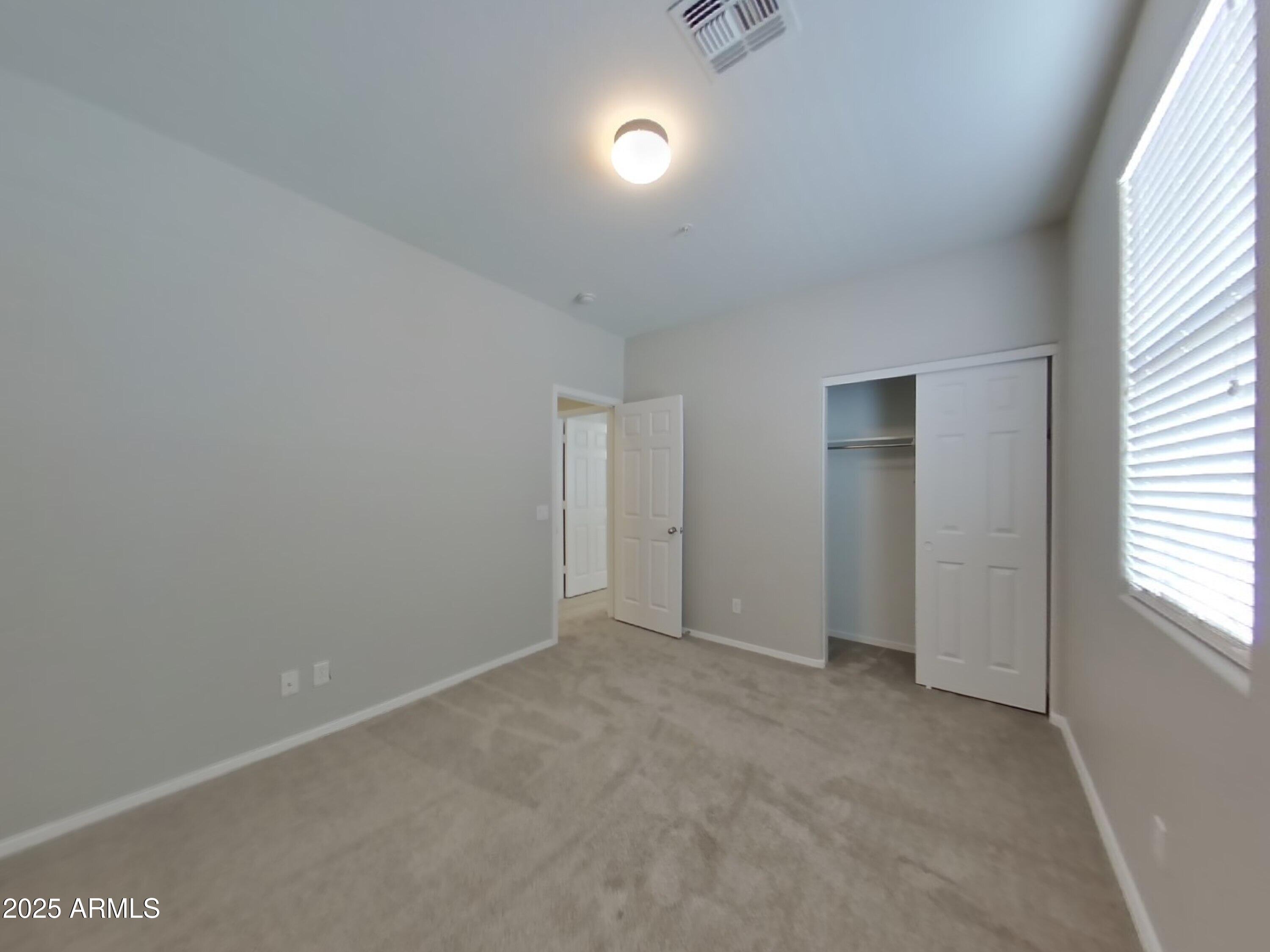1250 South Rialto, Unit 71 Mesa, AZ 85209 - Photo 9 of 13 an empty room with fan and windows
