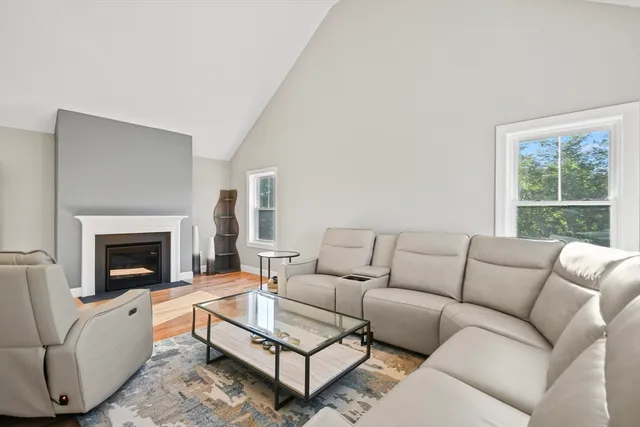 a living room with furniture a fireplace and next to a window