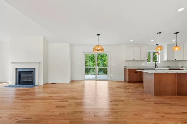 an open kitchen with granite countertop a stove and a wooden floor