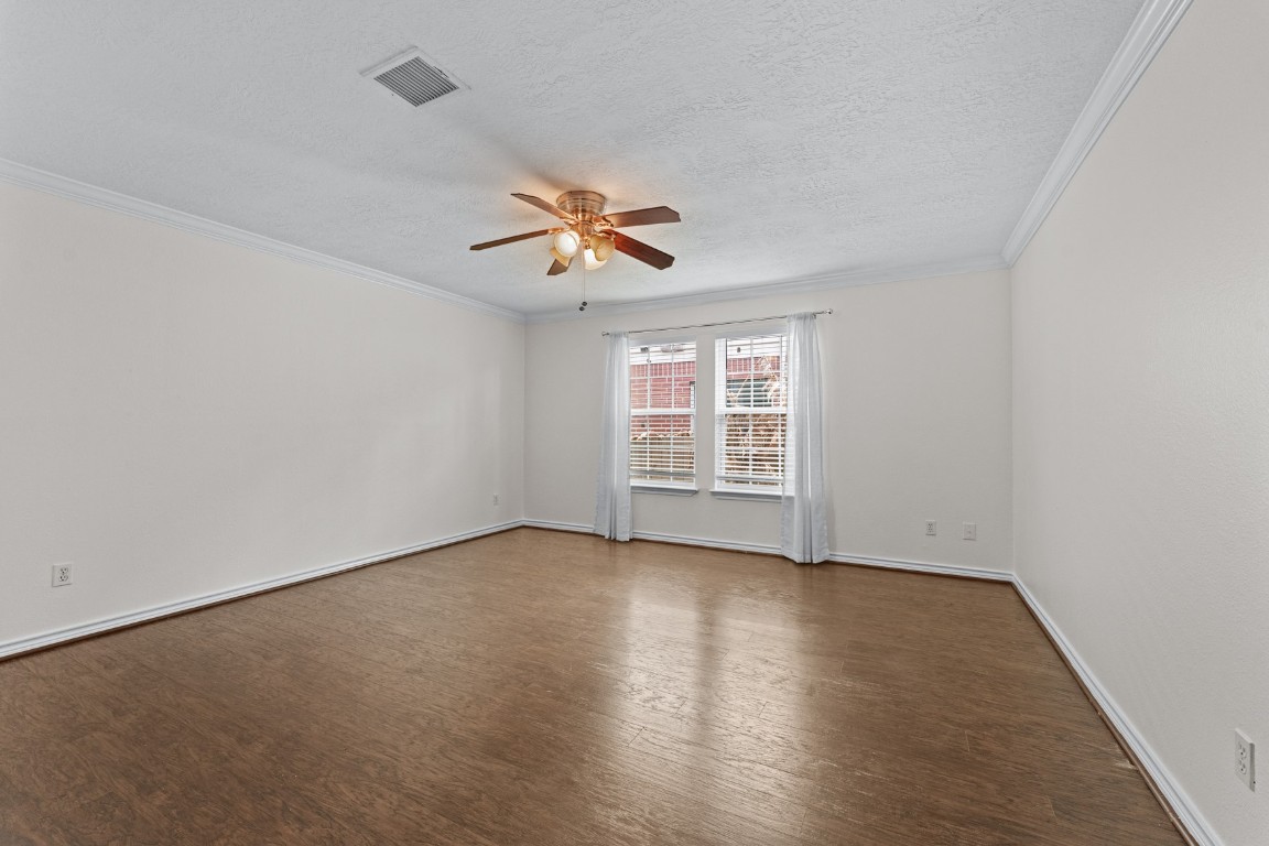 842 East 29th Street Houston, TX 77009 - Photo 12 of 24 an empty room with wooden floor chandelier fan and windows