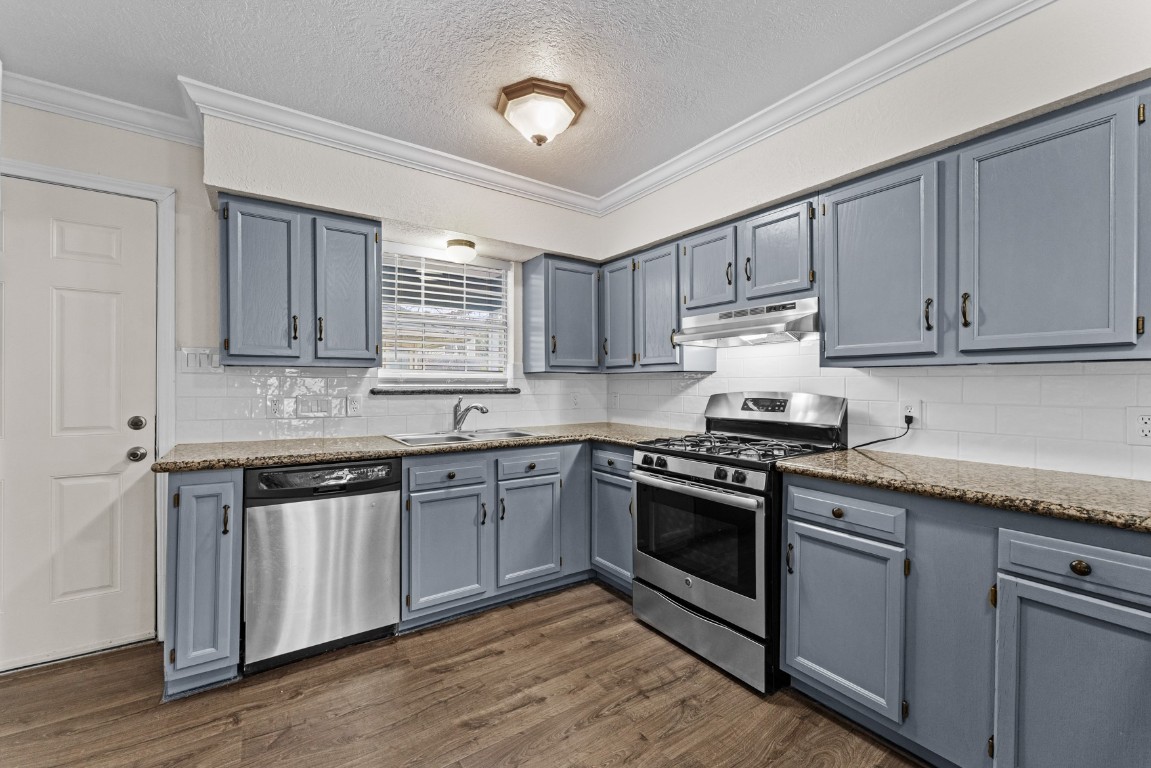 842 East 29th Street Houston, TX 77009 - Photo 10 of 24 a kitchen with granite countertop wooden cabinets and stainless steel appliances