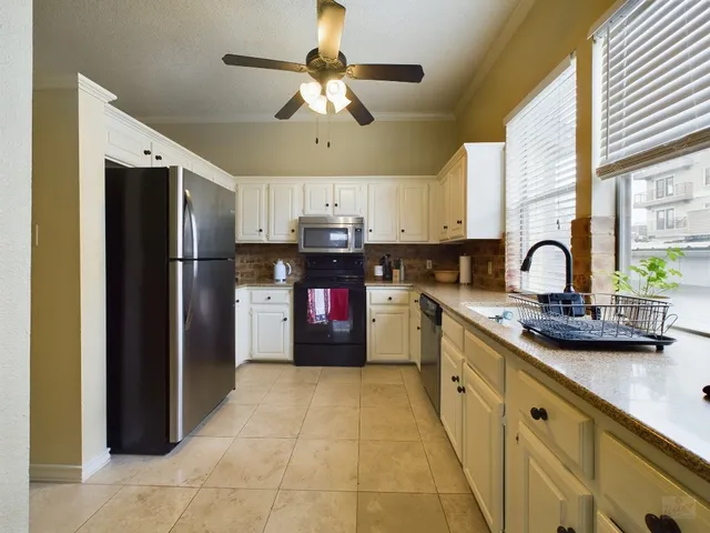 a kitchen with stainless steel appliances granite countertop a sink a stove and refrigerator