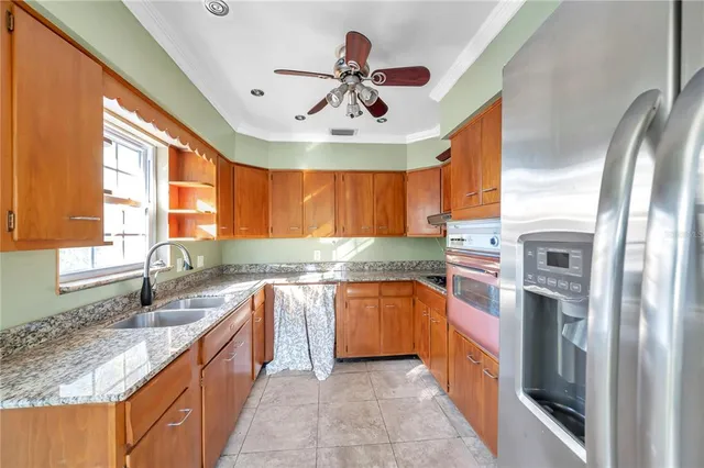 a large kitchen with stainless steel appliances granite countertop a sink counter space cabinets and a large window