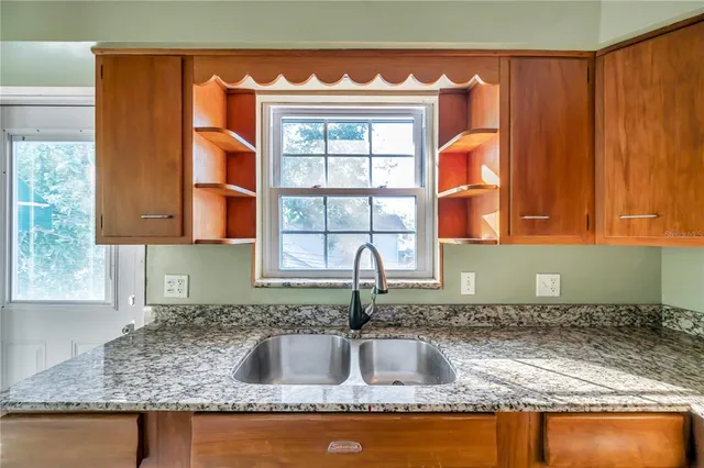 a kitchen with granite countertop a sink and a window
