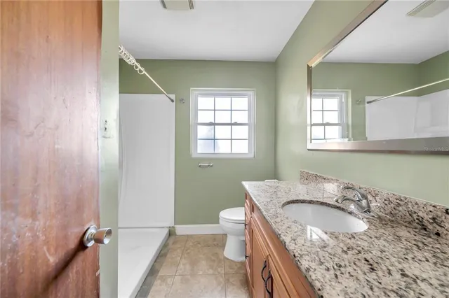 a bathroom with a granite countertop sink a toilet and a bathtub