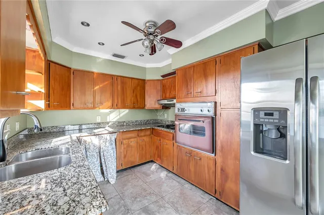 a kitchen with stainless steel appliances granite countertop a sink stove and refrigerator