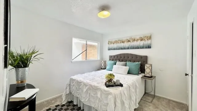 a bedroom with a bed and a potted plant