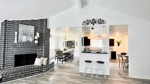 a living room with furniture a table and kitchen view