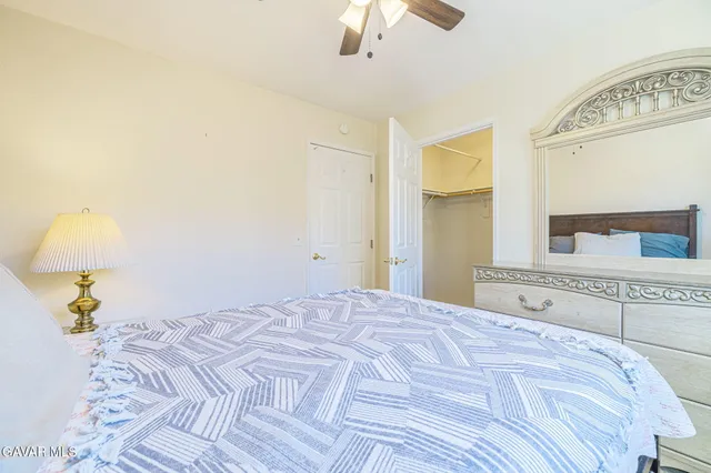 a bedroom with a large bed and a chandelier