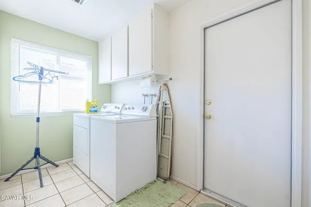 a utility room with cabinets washer and dryer