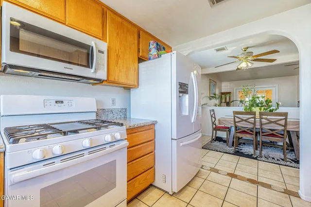 a kitchen with stainless steel appliances granite countertop a stove a microwave and a dining table chair