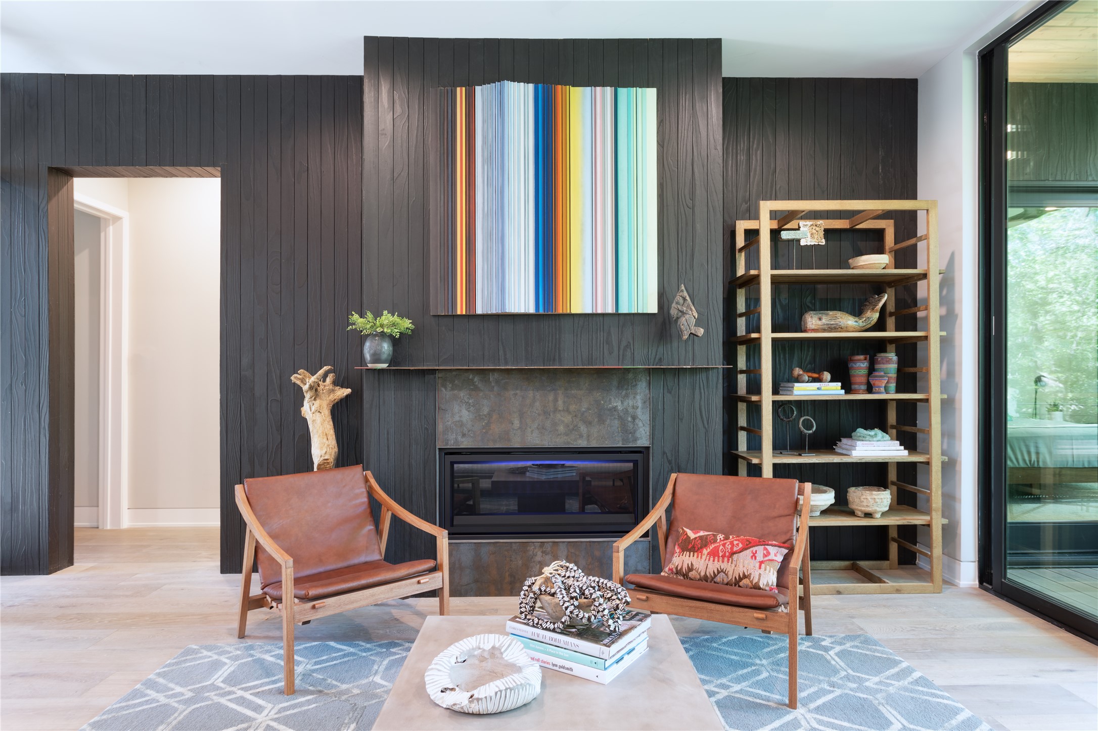 700 Jessie Street Austin, TX 78704 - Photo 9 of 40 Living area featuring light wood finished floors, a glass covered fireplace, and wooden walls