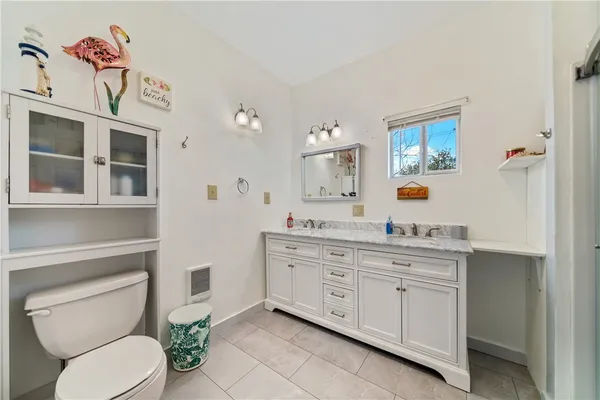 a bathroom with a granite countertop toilet sink and mirror