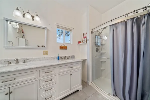 a bathroom with a granite countertop sink a mirror a vanity and a shower