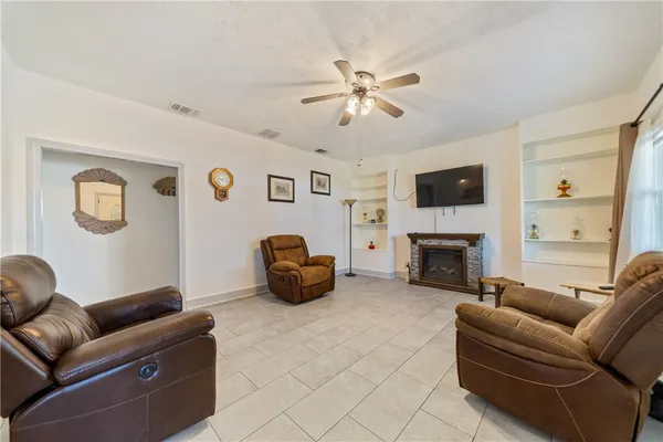 a living room with furniture a fireplace and a flat screen tv