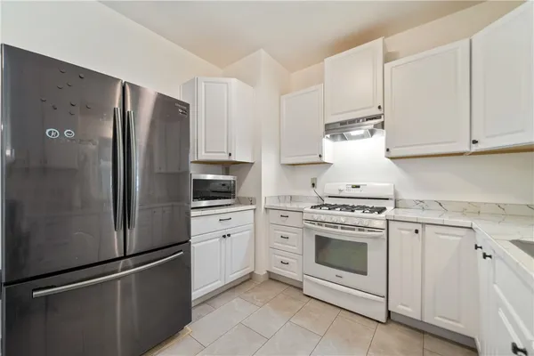 a kitchen with cabinets stainless steel appliances and a counter space