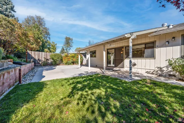 a view of a house with backyard and sitting area