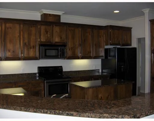 a kitchen with a refrigerator and a stove top oven