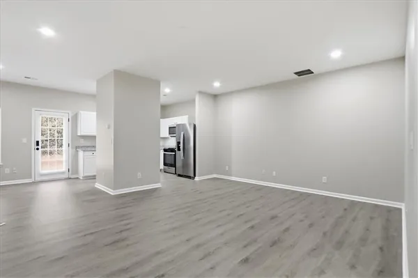 a view of an empty room with a fireplace and a window