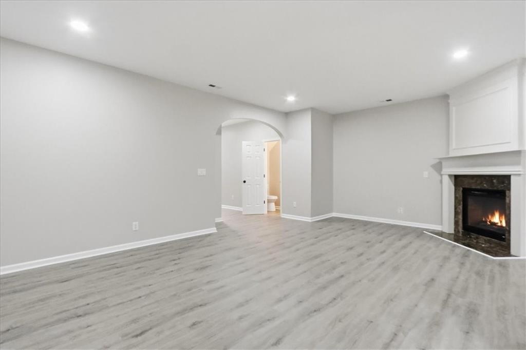 5630 Lawley Road Alpharetta, GA 30022 - Photo 14 of 65 a view of an empty room with wooden floor fireplace and a window