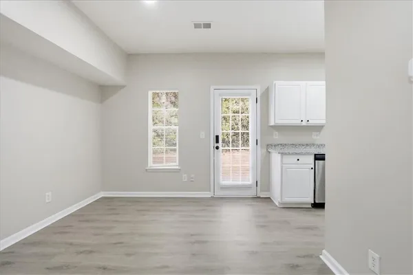 a kitchen with white cabinets and window