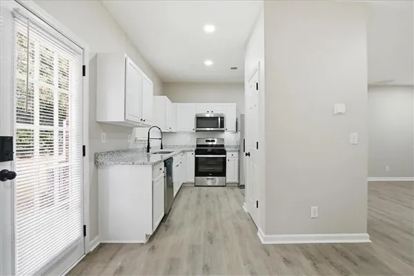 a kitchen with stainless steel appliances granite countertop a stove a sink and a refrigerator